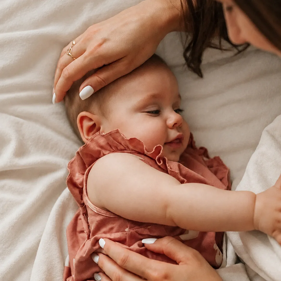 Madre acariciando la cabeza de su bebé mientras lo abraza